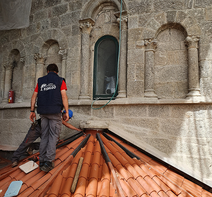 Fotografía de un hombre trabajando en un tejado de en una catedral