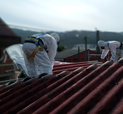 Fotografía de unos trabajadores trabajando sobre el tejado en un tejado de un edificio.