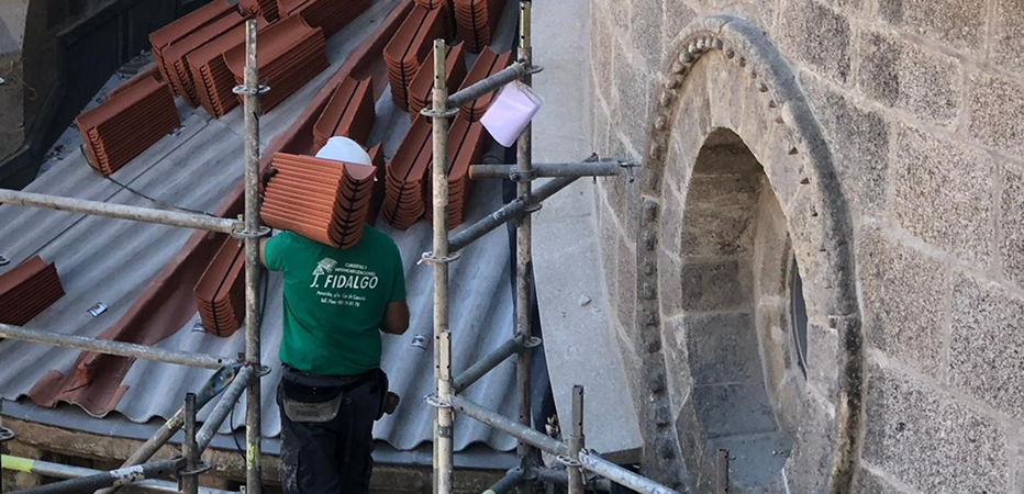 Fotografía de unos trabajadores arreglando una ventana de una iglesia
